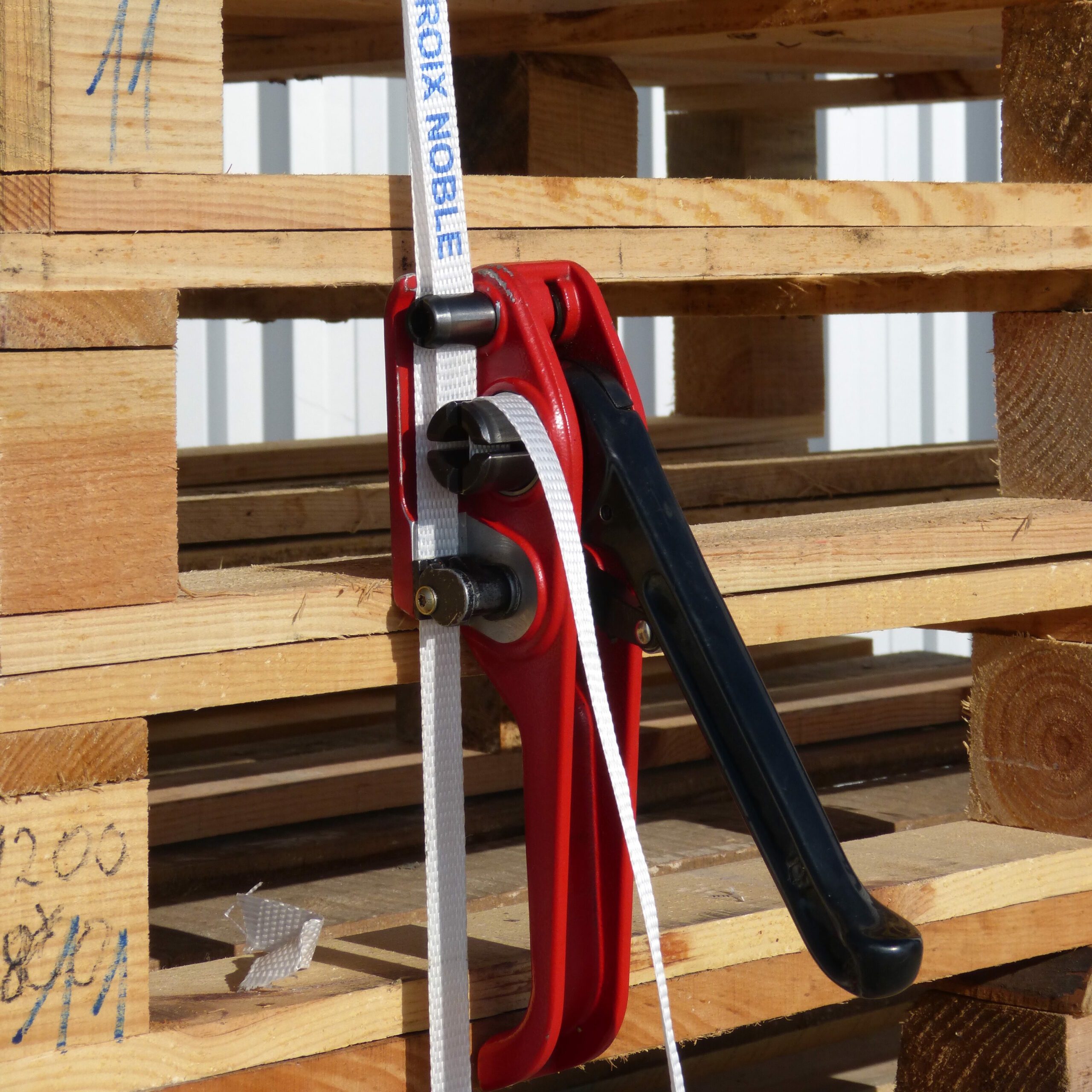 Manual strap tensioner for industrial packaging